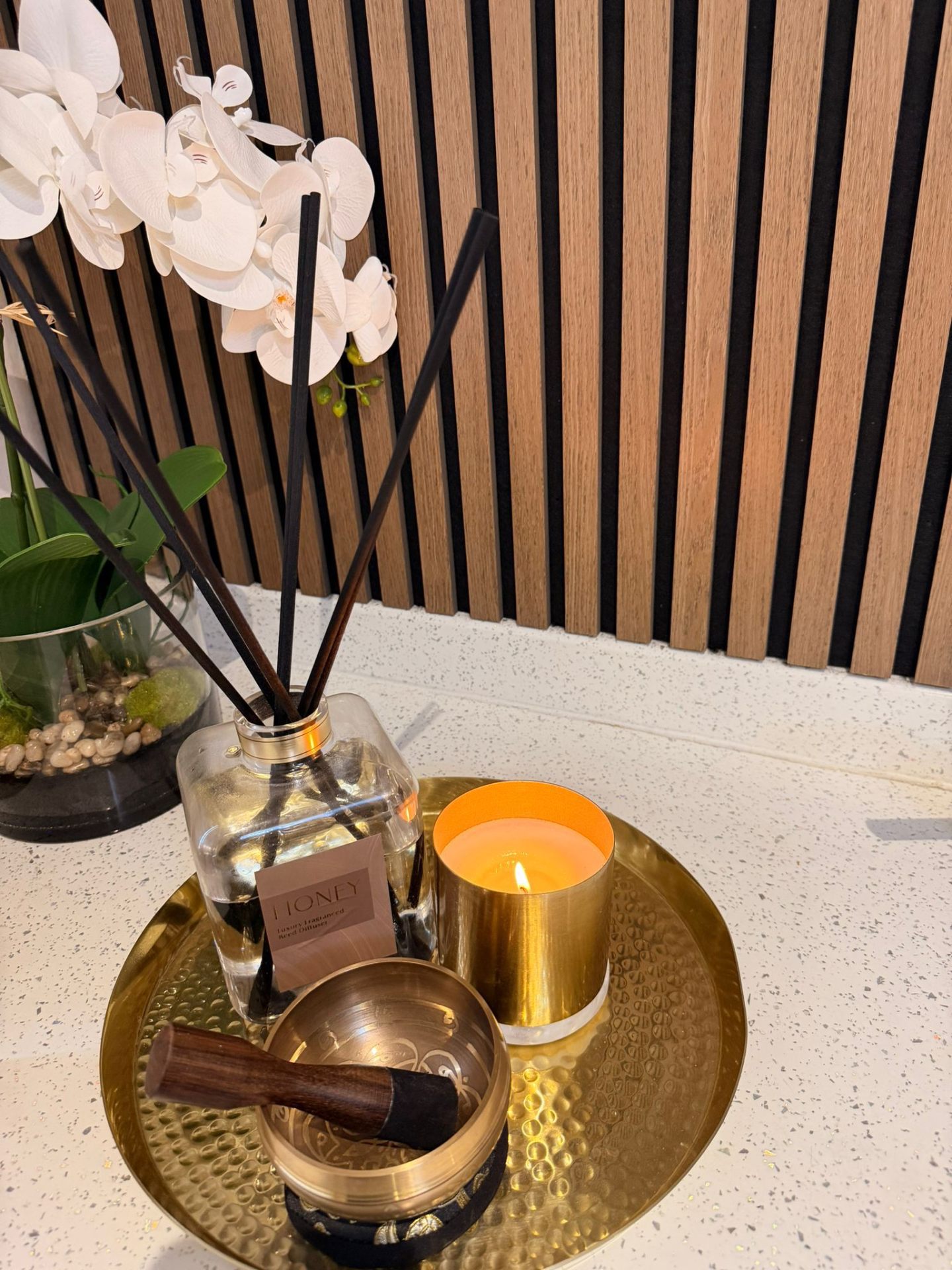 Honey reed diffuser, brass singing bowl and candle on a tray